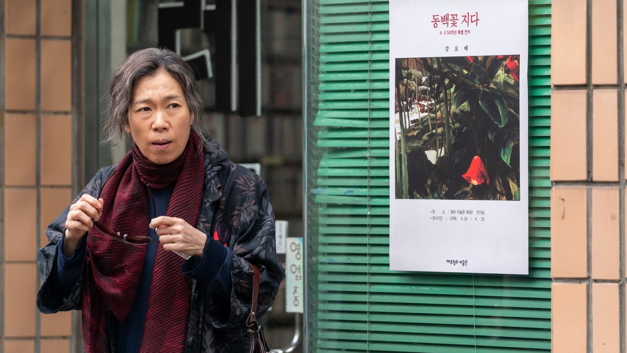 내 이름은 스틸, 동백꽃 지다 전시 포스터 옆의 여자