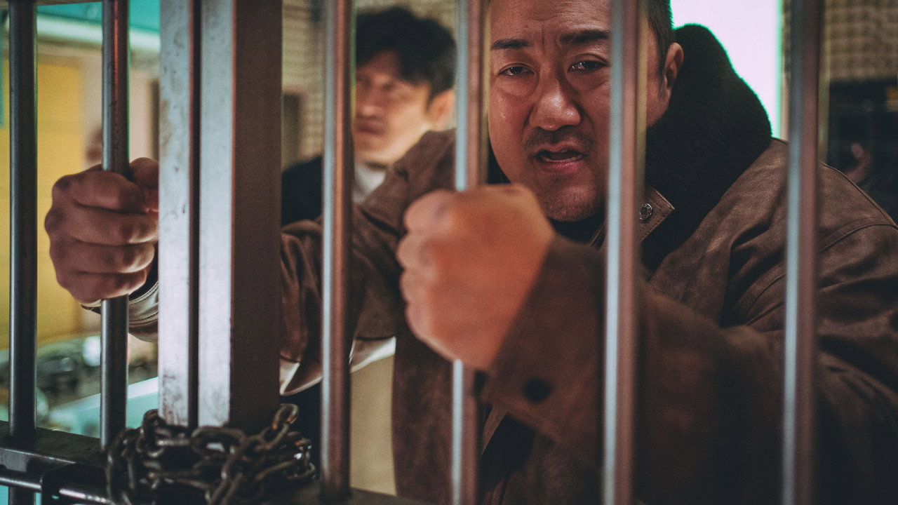 철창 사이로 주먹을 내민 마동석, 뒤에 다른 남자가 선 범죄도시4 스틸